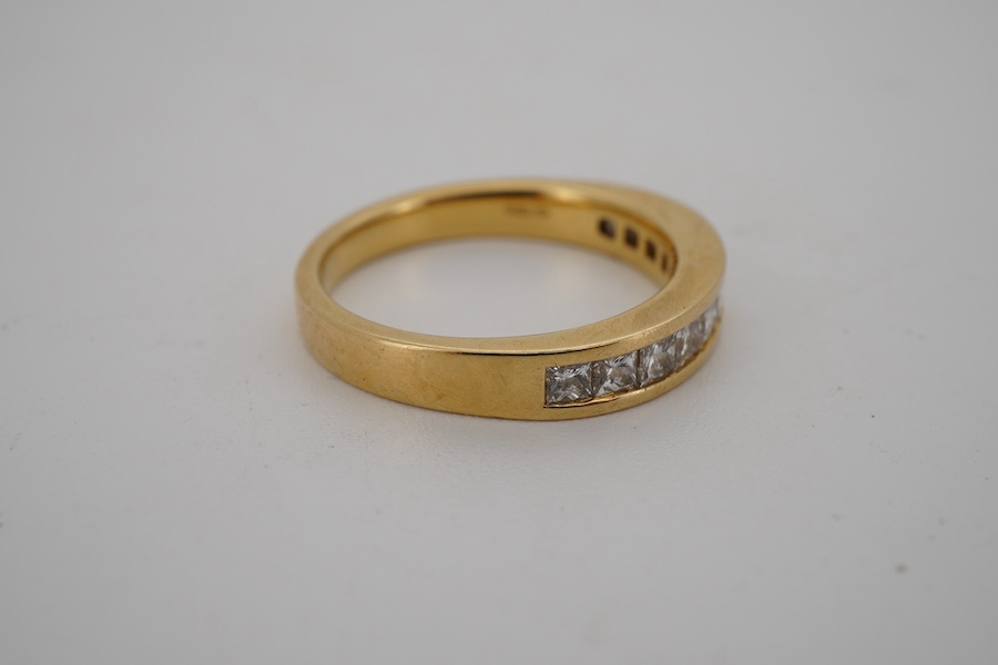 A diamond half hoop ring, channel-set to the front with princess-cut diamonds totalling approximately 0.60 carats, mounted in 18ct gold, size L, British hallmarks, gross weight approximately 4 grams